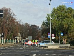 Zakaz ruchu ustawiony przy ulicy i widoczny radiowóz.