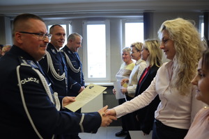 Pracownica służby cywilnej otrzymuje gratulacje od Komendanta Miejskiego Policji w Bytomiu.