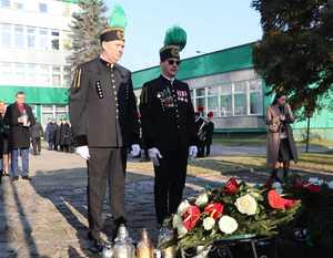 Na zdjęciu delegacja górnicza stoi pod pomnikiem.