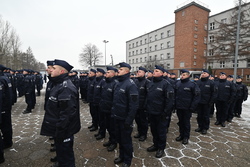 Zdjęcie przedstawia policjantów stojących na placu.