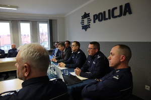 Na zdjęciu widzimy siedzących na auli bytomskiej komendy kolejno Zastępców Komendanta Miejskiego Policji w Bytomiu, Komendanta Miejskiego Policji w Bytomiu, Komendanta Wojewódzkiego Policji w Katowicach, Prezydenta Miasta Bytomia, Wiceprzewodniczącego Rady Miejskiej i Prokuratora Rejonowego