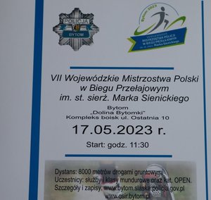 Plakat promujący imprezę. U góry widoczne logo Policji oraz imprezy. Pod spodem napis 7 Wojewódzkie Mistrzostwa Polski w biegu przełajowym imienia starszego sierżanta Marka Sienickiego. Bytom Dolina Bytomki kompleks boisk ulica Ostatnia 10. 17.05.2023 roku start godzina 11:30. Dystans 8000 metrów drogami gruntowymi.  Uczestnicy, służby i klasy mundurowe oraz kategoria open. Na dole link do zapisów i szczegółów. Impreza pod patronatem Prezydenta Miasta Bytomia. Na dole logotypy sponsorów i organizatorów: PEC,ZBM, BROKER, OSIR Bytom. Policja Śląska, Selgros, herb Urzędu Miasta Bytom,NSZZP