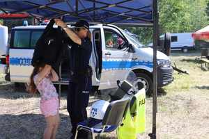 Policjantka zakładająca dziewczynce policyjną kamizelkę