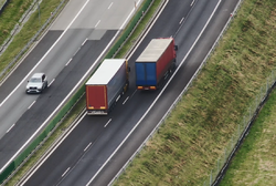 zdjęcie przedstawia autostradę i jadące po niej samochody ciężarowe