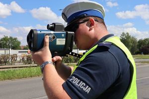 Na zdjęciu widzimy policjanta, który dokonuje pomiaru prędkości.