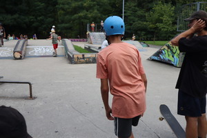 Na zdjęciu widoczny skatepark, dzieci jeżdżące na deskorolkach