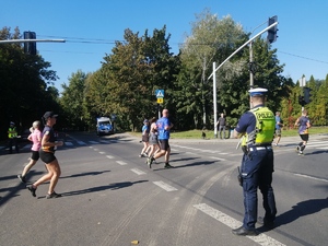 Na zdjęciu widzimy policjanta ruchu drogowego, który czuwa nad bezpieczeństwem biegaczy.