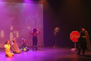 Na zdjęciu widzimy dzieci na scenie, chłopca w przebraniu lwa i chłopca w przebraniu czarnoksiężnika.