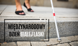 Na zdjęciu widzimy stopy, wysoki krawężnik, białą laskę i napis Międzynarodowy Dzień Białej Laski.