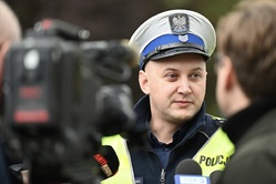 Na zdjęciu widzimy policjanta Wydziału Ruchu Drogowego, który udziela wywiadu przed kamerą.