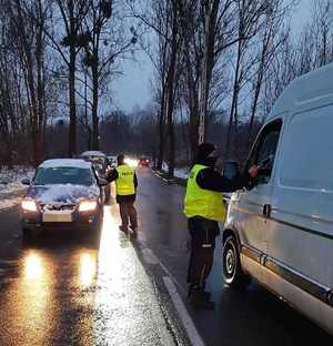 Zdjęcie przedstawia policjantów kontrolujących stan trzeźwości kierowców.