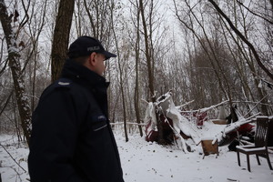 Na zdjęciu widzimy policjanta i szałas.