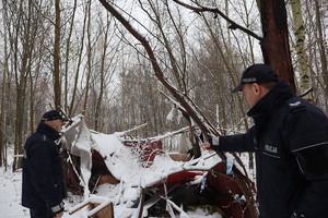 Zdjęcie przedstawia policjantów, którzy kontrolują miejsce, gdzie przebywały osoby bezdomne.