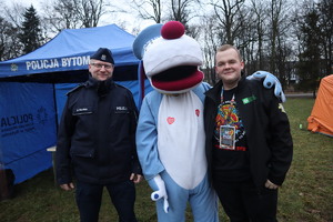 Policjant i maskotka śląskiej Policji z wolontariuszem Wielkiej Orkiestry Świątecznej Pomocy