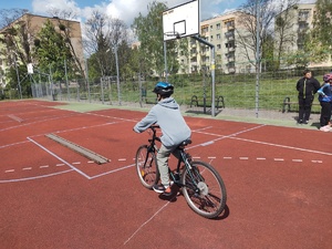 Na zdjęciu chłopiec jadący rowerem po torze przeszkód.
