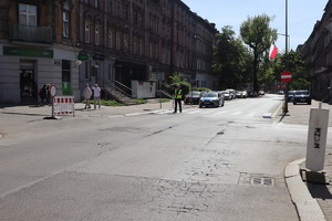 Na zdjęciu policjant bytomskiej drogówki, za  nim radiowóz.