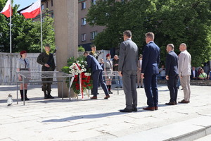 Na zdjęciu przedstawiciele miasta składający kwiaty przed pomnikiem.
