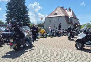 Na zdjęciu zgromadzone osoby i motocykle.