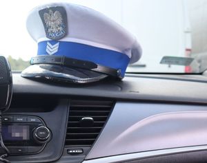 Na zdjęciu czapka policjanta ruchu drogowego znajdująca się w radiowozie, na podszybiu.