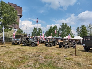 Na zdjęciu pojazdy militarne, za nimi stoiska.