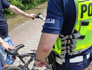 Na zdjęciu widzimy policjanta stojącego przy rowerzyście