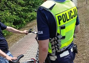 Na zdjęciu widzimy policjanta stojącego przy rowerzyście