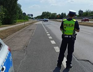 Na zdjęciu widzimy policjanta wykonującego pomiar prędkości