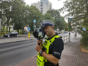 Na zdjęciu policjant wykonujący pomiar.