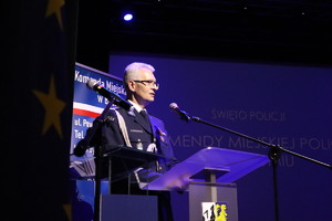 Na zdjęciu inspektor policji stojący przy mównicy.