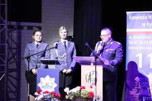 Na zdjęciu policjant i dwie policjantki przy mównicach.