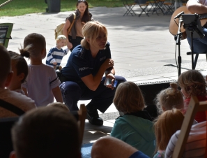 Na zdjęciu znajduje się policjantka w umundurowaniu oraz dzieci