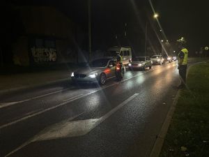 Na zdjęciu policjanci znajdujący się na drodze sprawdzający stan trzeźwości kierujących.