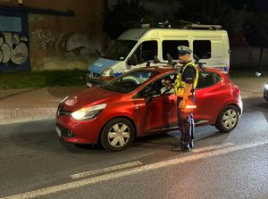 Na zdjęciu policjant znajdujący się na drodze sprawdzający stan trzeźwości kierującego.