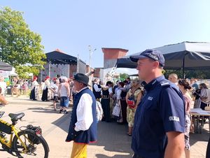 Na zdjęciu policjant przemieszczający się pośród zgromadzonych uczestników wydarzenia.