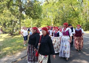 Na zdjęciu kobiety w kolorowych sukniach maszerujące w korowodzie.