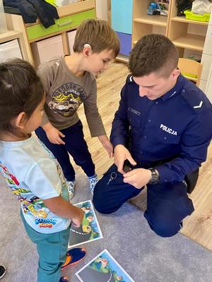 Na zdjęciu policjant wraz z przedszkolakami.