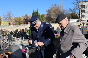 Zastępca Komendanta Miejskiego Policji w Bytomiu zapalający znicz i Pan Józef Sienicki