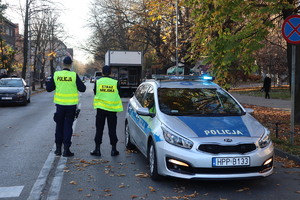 policjant i strażnik miejski przy radiowozie