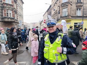 na zdjęciu policjant, za nim orszak