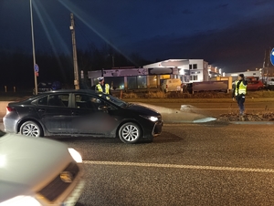 na zdjęciu policjanci na jezdni w trakcie wykonywania badań stanu trzeźwości kierujących