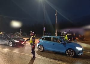 na zdjęciu policjanci na jezdni w trakcie wykonywania badań stanu trzeźwości kierujących