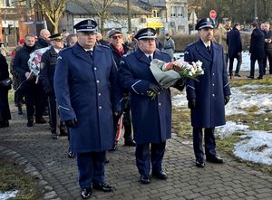 na zdjęciu Komendant Miejski Policji w Bytomiu trzymający kwiaty stojący pomiędzy komendantami bytomskich komisariatów.