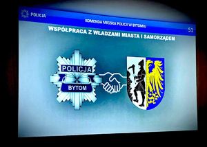 na zdjęciu wyświetlony na ścianie slajd prezentacji na którym widnieją napisy Komenda Miejska Policji w Bytomiu, współpraca z władzami miasta i samorządem, poniżej widoczna gwiazda policyjna na której umieszczony jest napis Policja Bytom i tuż obok godło miasta Bytomia