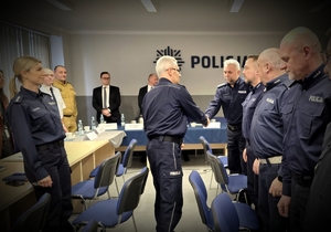 na zdjęciu generał podający dłoń jednemu ze stojących na przeciwko niego policjantów