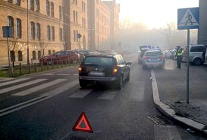 na zdjęciu znajdujący się na pasach samochód osobowy, obok policjanci i radiowóz służbowy