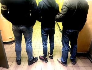 na zdjęciu zatrzymany stojący pomiędzy nieumundurowanymi policjantami