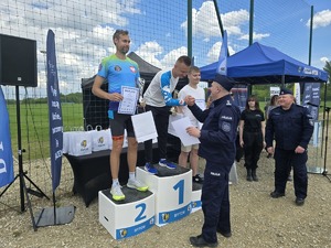 na zdjęciu komendant i naczelnik wręczający nagrody osobom stojącym na podium
