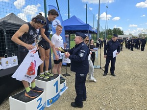 na zdjęciu komendant wręczający nagrody osobom stojącym na podium