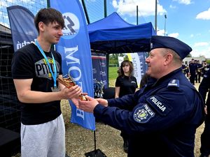 na zdjęciu komendant wręczający nagrody osobom stojącym na podium