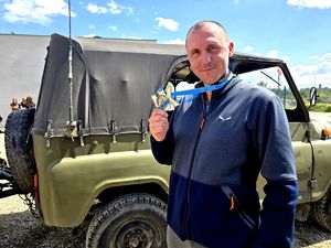 na zdjęciu mężczyzna z medalem, za mim wóz militarny